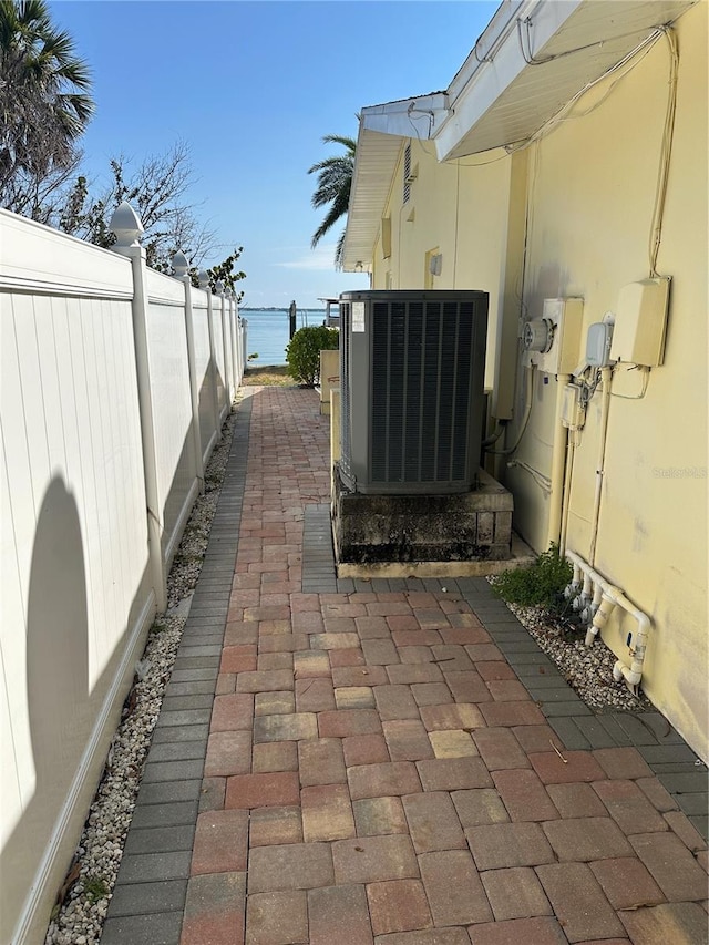 view of patio / terrace featuring central air condition unit and fence