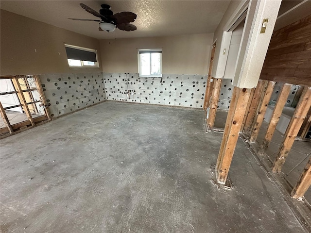 interior space with unfinished concrete flooring and ceiling fan