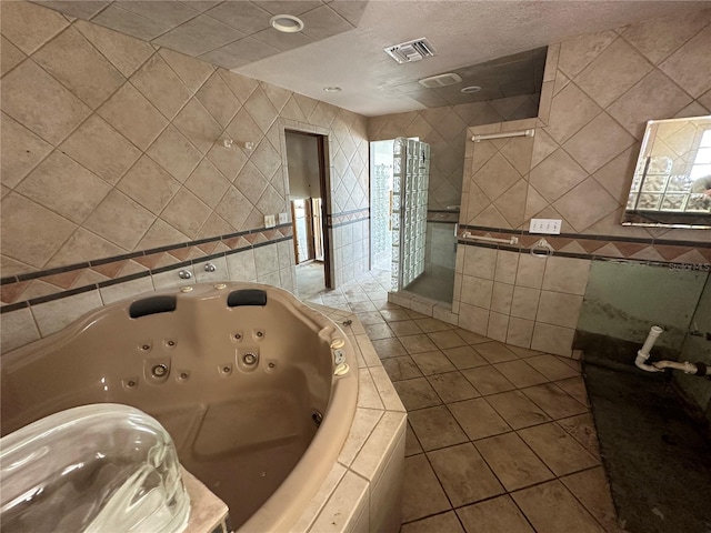 full bath featuring visible vents, a whirlpool tub, a shower stall, tile walls, and tile patterned floors