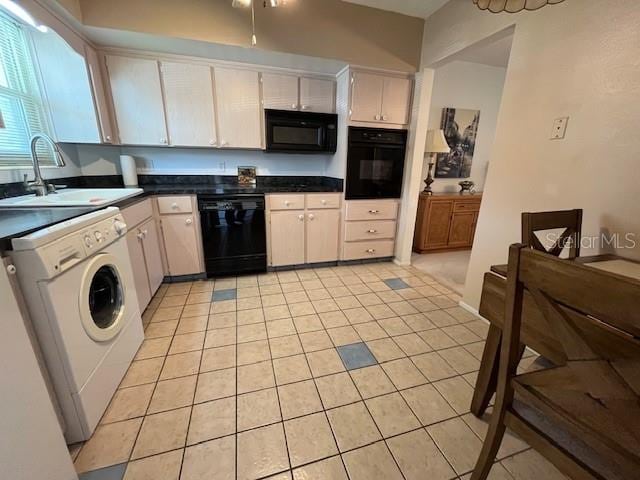 kitchen with lofted ceiling, washer / clothes dryer, light tile patterned floors, black appliances, and sink