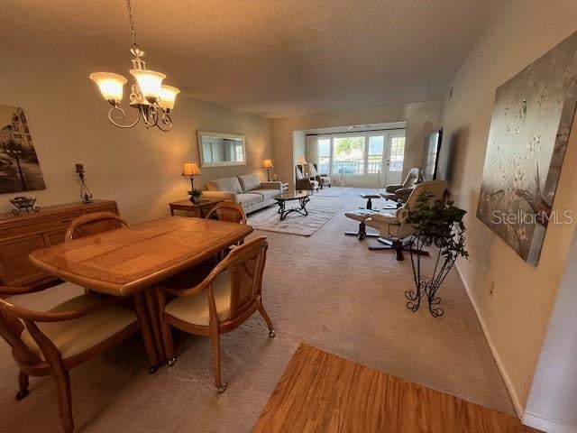 dining space featuring a chandelier and light colored carpet