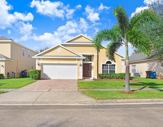 view of front of property featuring a front yard, central AC, and a garage