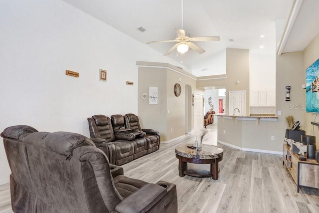 living room with ceiling fan, high vaulted ceiling, and light wood-type flooring