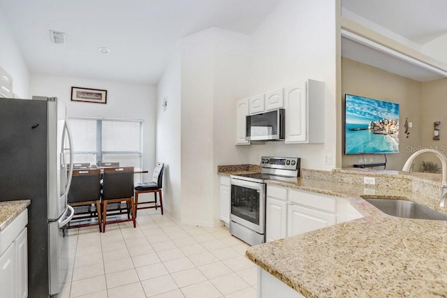 163 Andalusia Loop, Davenport, FL 33837 - kitchen with stainless steel appliances, a sink, white cabinetry, and light stone countertops