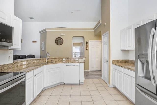 163 Andalusia Loop, Davenport, FL 33837 - kitchen with appliances with stainless steel finishes, a sink, light tile patterned floors, white cabinetry, and light stone counters