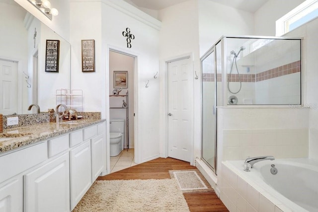 163 Andalusia Loop, Davenport, FL 33837 - full bath with vanity, a shower stall, a garden tub, toilet, and wood finished floors