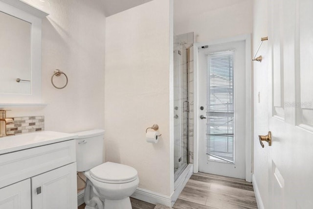 163 Andalusia Loop, Davenport, FL 33837 - bathroom with vanity, a shower stall, toilet, wood finished floors, and backsplash