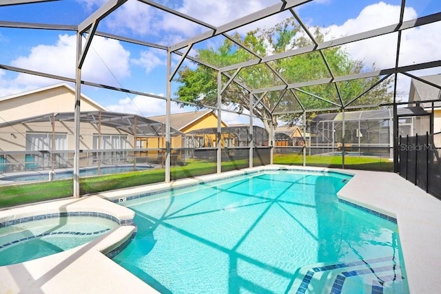 view of pool with an in ground hot tub, a patio area, and glass enclosure