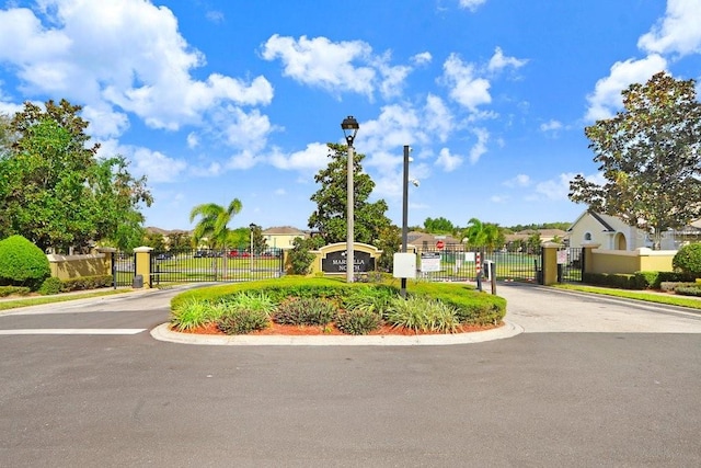 163 Andalusia Loop, Davenport, FL 33837 - view of asphalt road featuring a gate, street lights, and a gated entry