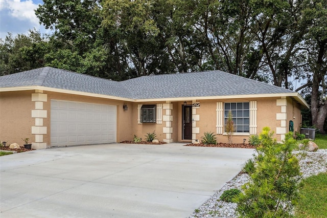 ranch-style house featuring central AC and a garage