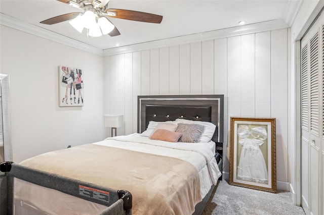 carpeted bedroom featuring a closet, ceiling fan, crown molding, and a fireplace