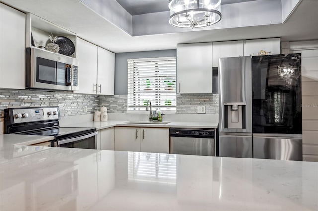 kitchen featuring white cabinetry, backsplash, stainless steel appliances, and sink