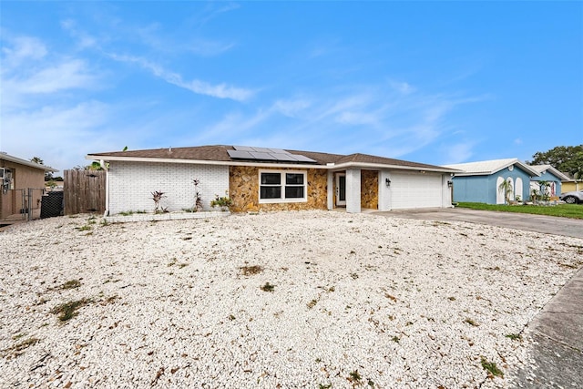 ranch-style house with solar panels and a garage