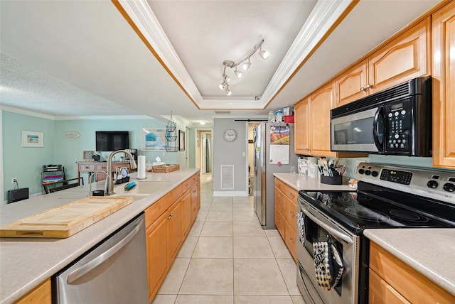 kitchen with sink, stainless steel appliances, a tray ceiling, light tile patterned floors, and ornamental molding