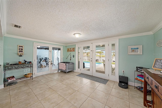 entryway with french doors, light tile patterned floors, and a textured ceiling