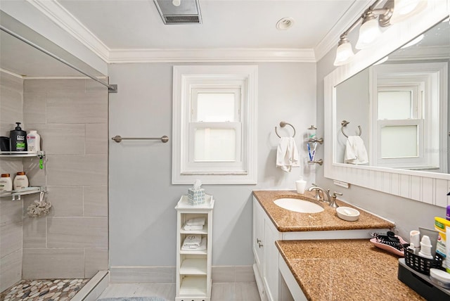 bathroom featuring vanity, a tile shower, and ornamental molding