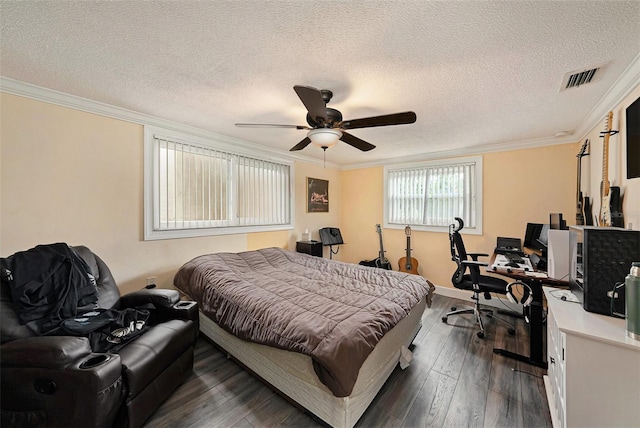 bedroom with a textured ceiling, ceiling fan, crown molding, and dark wood-type flooring