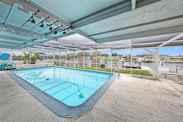 view of pool with glass enclosure, a water view, and a patio