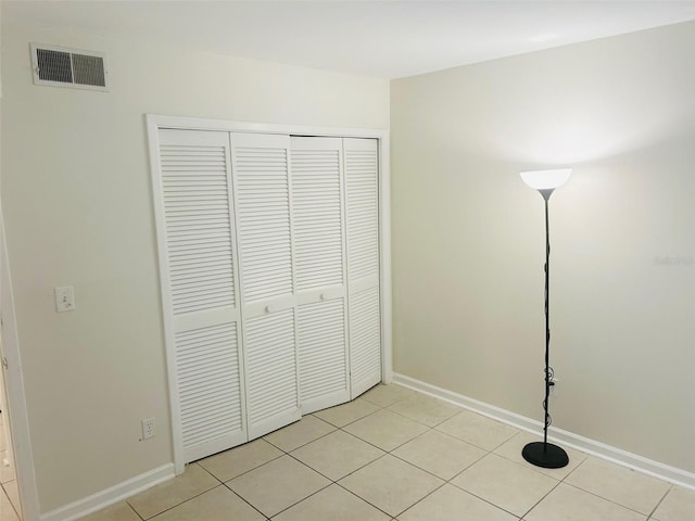 unfurnished bedroom featuring light tile patterned floors and a closet