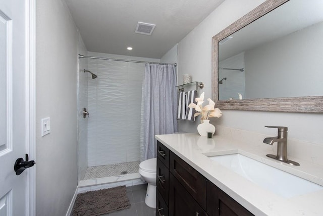 bathroom with toilet, vanity, tile patterned floors, and curtained shower