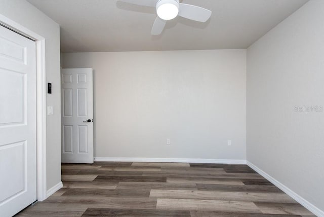 empty room with dark hardwood / wood-style flooring and ceiling fan