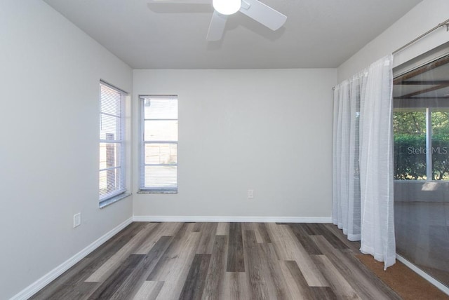 unfurnished room with dark hardwood / wood-style flooring and ceiling fan