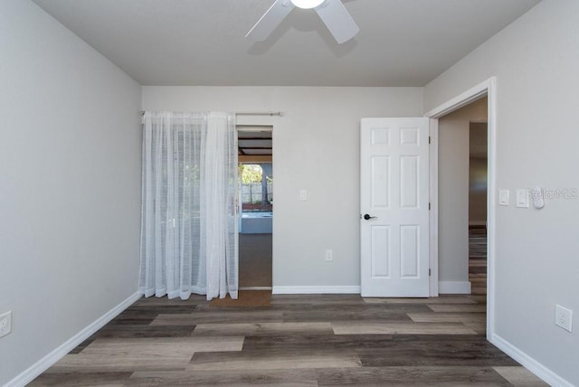 unfurnished room featuring dark wood-type flooring and ceiling fan