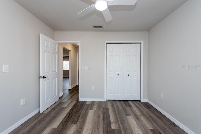 unfurnished bedroom with ceiling fan, dark hardwood / wood-style floors, and a closet