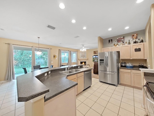 kitchen featuring light tile patterned flooring, a center island with sink, stainless steel appliances, decorative light fixtures, and sink