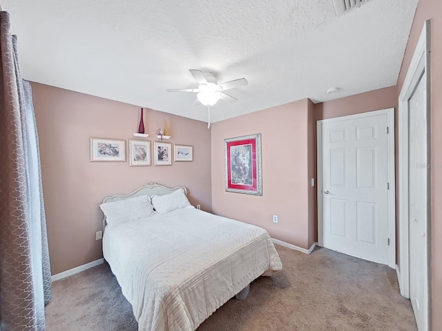 bedroom featuring ceiling fan, a textured ceiling, and light colored carpet