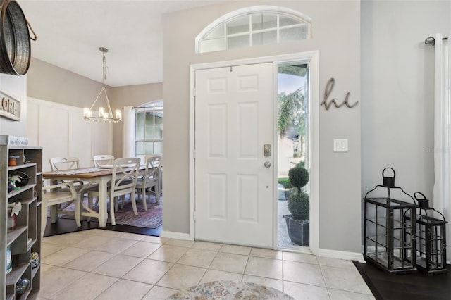 tiled foyer featuring an inviting chandelier