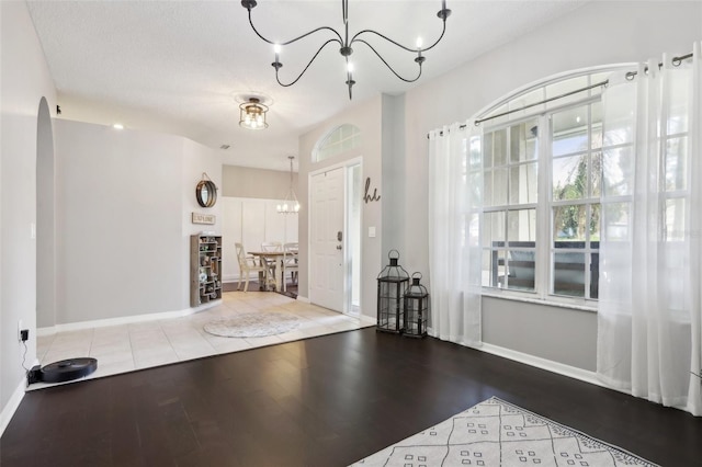 workout area featuring hardwood / wood-style floors, a notable chandelier, and a textured ceiling