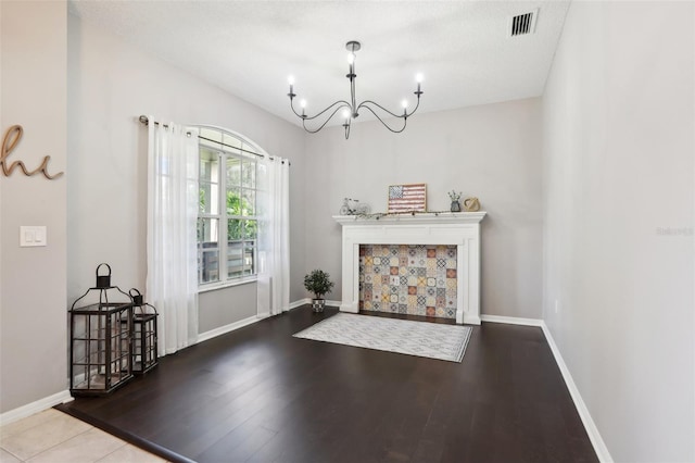 living room featuring wood-type flooring, a textured ceiling, and a notable chandelier