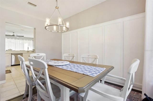 tiled dining area with sink and ceiling fan with notable chandelier