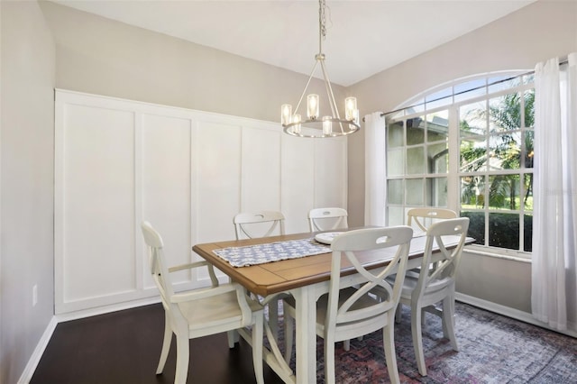 dining room with dark hardwood / wood-style flooring and a notable chandelier