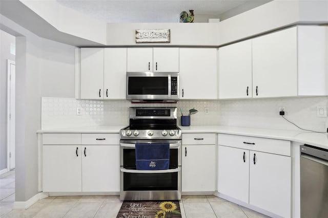 kitchen featuring white cabinets, light tile patterned floors, stainless steel appliances, and decorative backsplash