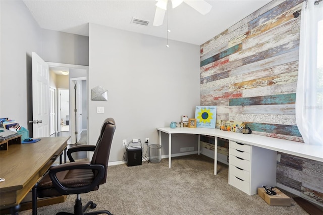 office space featuring light carpet, wooden walls, and ceiling fan