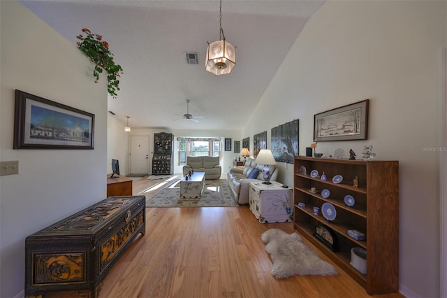 living room with light hardwood / wood-style flooring, high vaulted ceiling, and ceiling fan