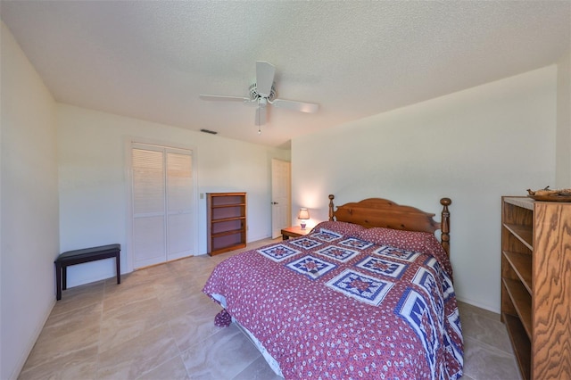 bedroom with a closet, a textured ceiling, and ceiling fan