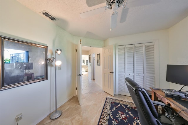 office area with ceiling fan and a textured ceiling