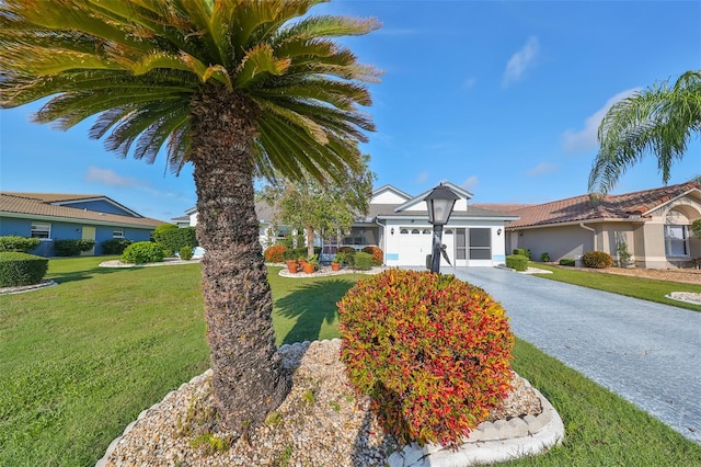 ranch-style house featuring a garage and a front lawn