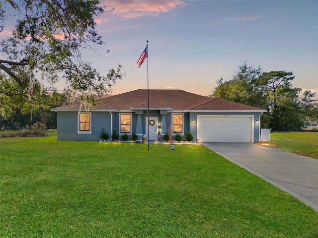 ranch-style home with a garage and a yard