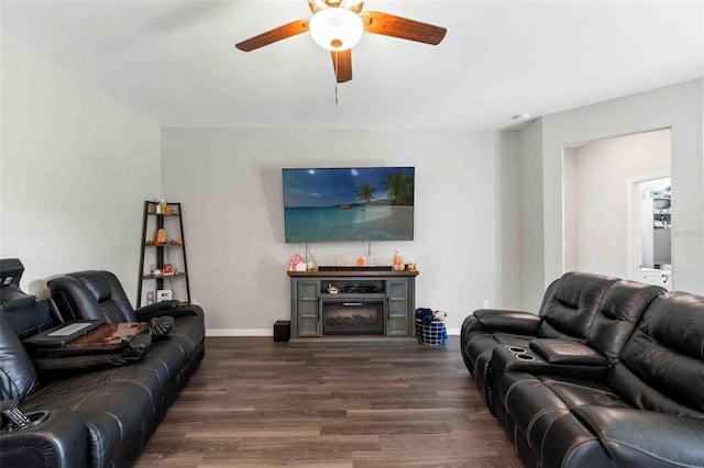 living room with a fireplace, dark hardwood / wood-style flooring, and ceiling fan