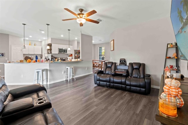 living room featuring dark wood-type flooring and ceiling fan