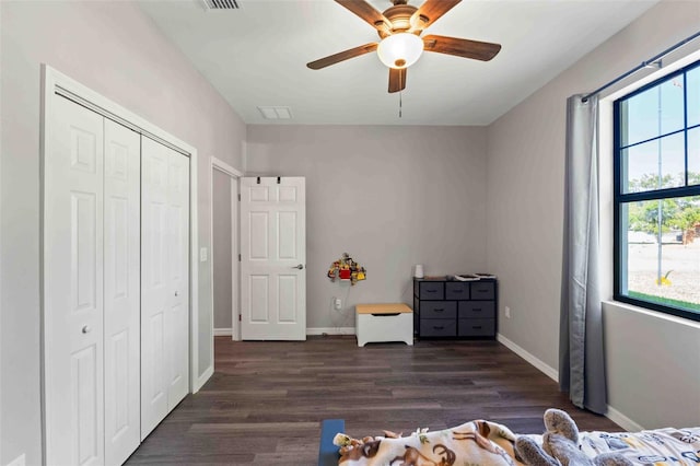 unfurnished bedroom with dark wood-type flooring, ceiling fan, and a closet