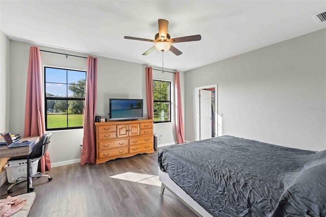 bedroom with wood-type flooring, multiple windows, and ceiling fan