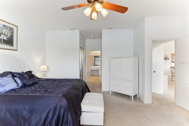 carpeted bedroom with ensuite bathroom and ceiling fan