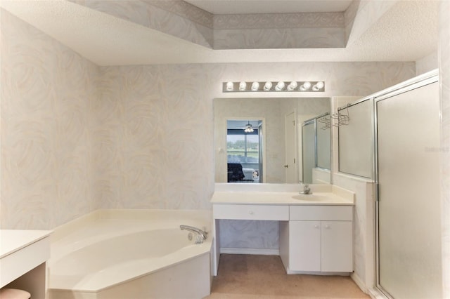 bathroom with shower with separate bathtub, vanity, a textured ceiling, and a raised ceiling