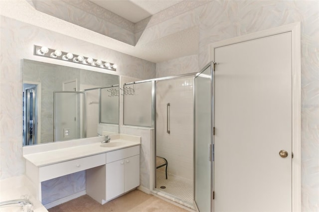 bathroom with walk in shower, vanity, and a textured ceiling