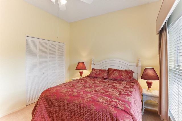 bedroom featuring light colored carpet, ceiling fan, and a closet